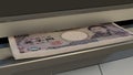 5000 Japanese yen in cash dispenser. Withdrawal of cash from an ATM. JPY. 3d render.