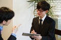 Young businessman asking leader to check his plan with tablet device