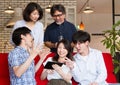 Japanese young and mature people talking and watching contents on the internet with tablet device