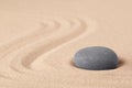 Japanese zen meditation garden with a round stone on sandy background with copy space