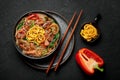 Japchae in black bowl on dark slate table top. Korean cuisine glass chapchae noodles dish with vegetables and meat Royalty Free Stock Photo