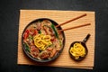 Japchae in black bowl on dark slate table top. Korean cuisine glass chapchae noodles dish with vegetables and meat Royalty Free Stock Photo