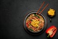 Japchae in black bowl on dark slate table top. Korean cuisine glass chapchae noodles dish with vegetables and meat Royalty Free Stock Photo