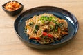 Japchae or stir-fried Korean vermicelli noodles with vegetables and pork topped with white sesame