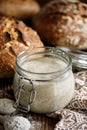 A jar with active rye sourdough for baking bread on a wooden table