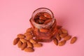 Jar with almonds and honey on pink background Royalty Free Stock Photo