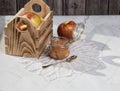 A jar of applesauce and apples in a wooden box on a light background with a lace napkin.