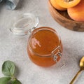 A jar of apricot jam, next to it is a spoon and a plate with ripe apricots. The concept of fruit conservation. Royalty Free Stock Photo