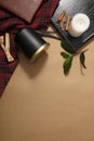 A jar of black scented candles is placed on the table with a checkered tablecloth, green leaves, notebook, cinnamon and wooden Royalty Free Stock Photo