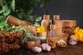 Jar, bottles of essential oils and different herbs on wooden table Royalty Free Stock Photo