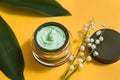 Jar of camomile face cream with camomile flowers with selective focus. Cosmetics pink background Royalty Free Stock Photo