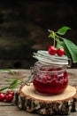 Jar of cherry jam and sour cherries. Berries cherry with syrup. Ripe ripe cherries. Sweet red cherries. Canned fruit on a wooden Royalty Free Stock Photo