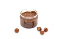 Jar of chocolate hazelnut spread, bunch of hazelnuts on white. Hazelnut butter, natural, organic product