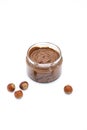 Jar of chocolate hazelnut spread, bunch of hazelnuts on white. Hazelnut butter, natural, organic product