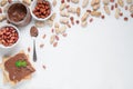 Jar of chocolate paste. Decorated with peanuts and hazelnuts. Next to a can of toast and a spoon..Flat lay composition. View from Royalty Free Stock Photo