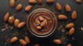 A jar of chocolate smoothie surrounded by almonds on a dark surface Royalty Free Stock Photo