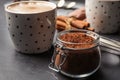 Jar with cocoa powder and cup of hot drink on table Royalty Free Stock Photo