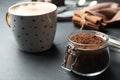 Jar with cocoa powder and cup of hot drink on table Royalty Free Stock Photo