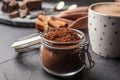 Jar of cocoa powder on grey table