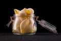 Jar of conchiglie pasta shell on wooden table isolated on black background Royalty Free Stock Photo