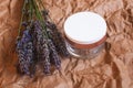 Jar of cream with a bouquet of fragrant fresh lavender flowers on beige kraft paper Royalty Free Stock Photo