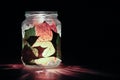 The jar decorated with autumn leaves with a candle inside