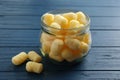 Jar of delicious crispy corn sticks on blue wooden table