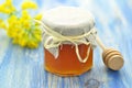 Jar of delicious honey in a jar with rapeseed flowers