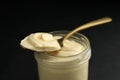 Jar of delicious mayonnaise and spoon on black table, closeup Royalty Free Stock Photo