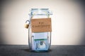 Jar with dollar bills and board sign with text For Emergency. Royalty Free Stock Photo