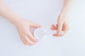 A jar of face cream on the table in hand of a Caucasian woman. white background