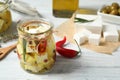 Jar with feta cheese marinated in oil on white wooden table Royalty Free Stock Photo