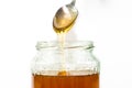 Jar filled with delicious honey, puring honey from the spoon