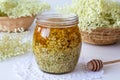 A jar filled with fresh elder flowers and honey, to prepare syrup Royalty Free Stock Photo