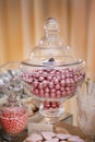 Jar Filled with Pink Foil Wrapped Chocolate Candy, Jelly Beans and Heart Shaped Cookies On A Table Decorated for a Wedding Royalty Free Stock Photo