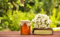 A jar of flower honey, an old book and a bouquet of wildflowers. Copy space