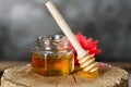 Jar with fresh bee honey and wooden dipper on a gray background. Space for text Royalty Free Stock Photo