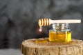 Jar with fresh bee honey and wooden dipper on a gray background. Space for text Royalty Free Stock Photo