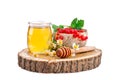 A jar of fresh honey, chamomile and red currants on a white background.