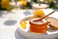 Jar with fresh rose honey on white wooden table. Space for text