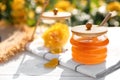 Jar with fresh rose honey on white wooden table. Space for text