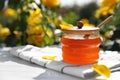 Jar with fresh rose honey on white wooden table. Space for text