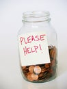 Jar full of pennies with PLEASE HELP sign Royalty Free Stock Photo