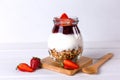 Jar of granola with yogurt, strawberry jam and fresh strawberries on a white wooden background. Healthy food Royalty Free Stock Photo
