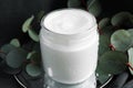 Jar of hand cream and eucalyptus branches on grey background, closeup Royalty Free Stock Photo