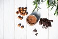 Jar of hazelnut butter, bunch of hazelnuts on white wooden table. Homemade hazelnut butter, natural, organic product. Modern