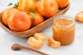 Jar of healthy tangerine jam and wooden bowl of mandarin oranges fruits on kitchen table Royalty Free Stock Photo