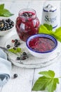 Jar of homemade fresh currant jam with shugar. Fresh berries black currant on white wooden background