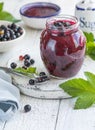 Jar of homemade fresh currant jam with shugar. Fresh berries black currant on white wooden background