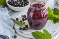 Jar of homemade fresh currant jam with shugar. Fresh berries black currant on white wooden background